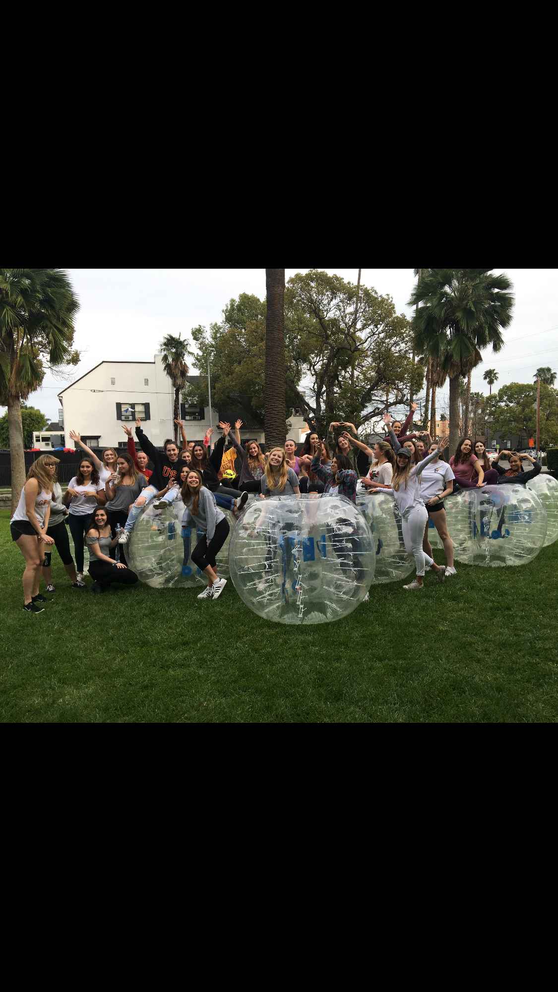 Large group of women celebrating with bubble suits at park