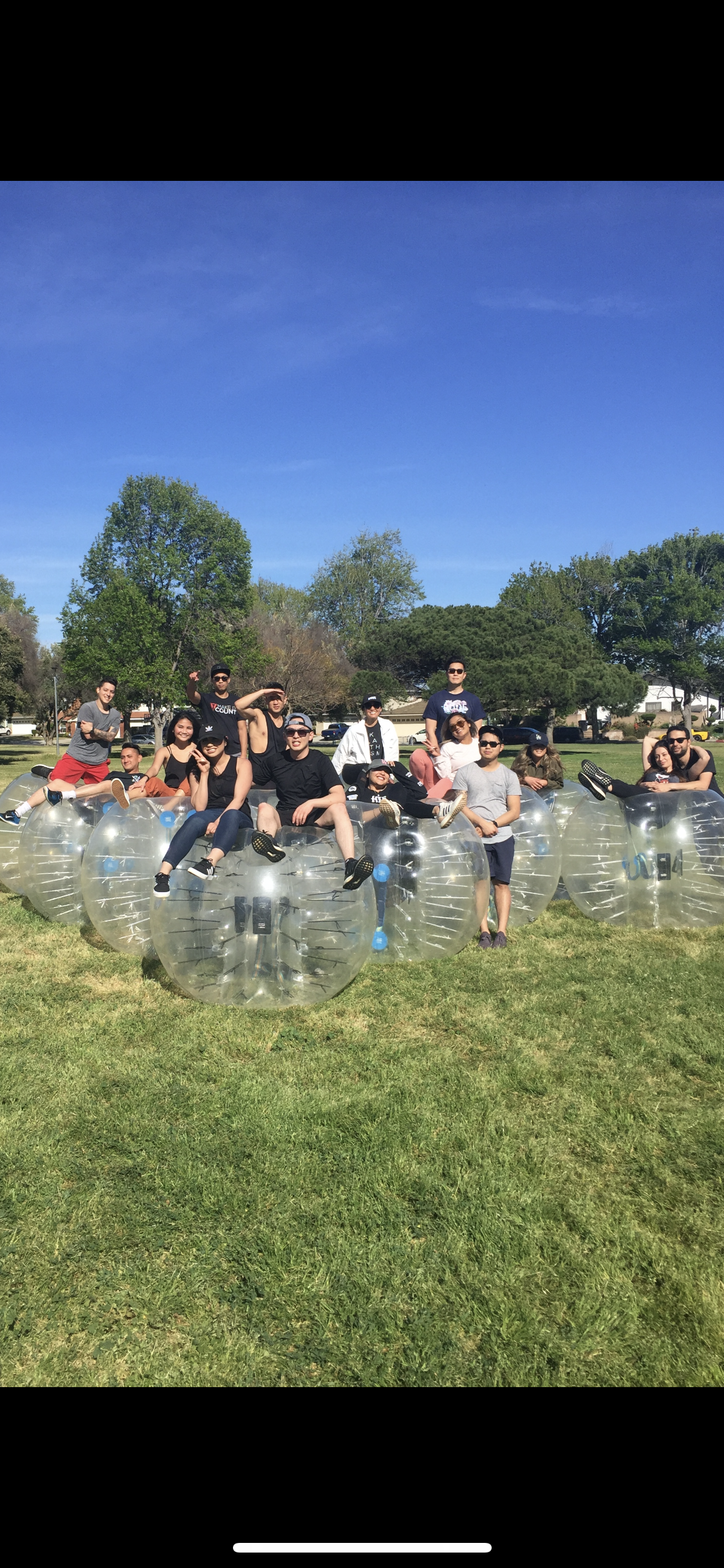 Group sitting on bubble suits at sunny park in LA